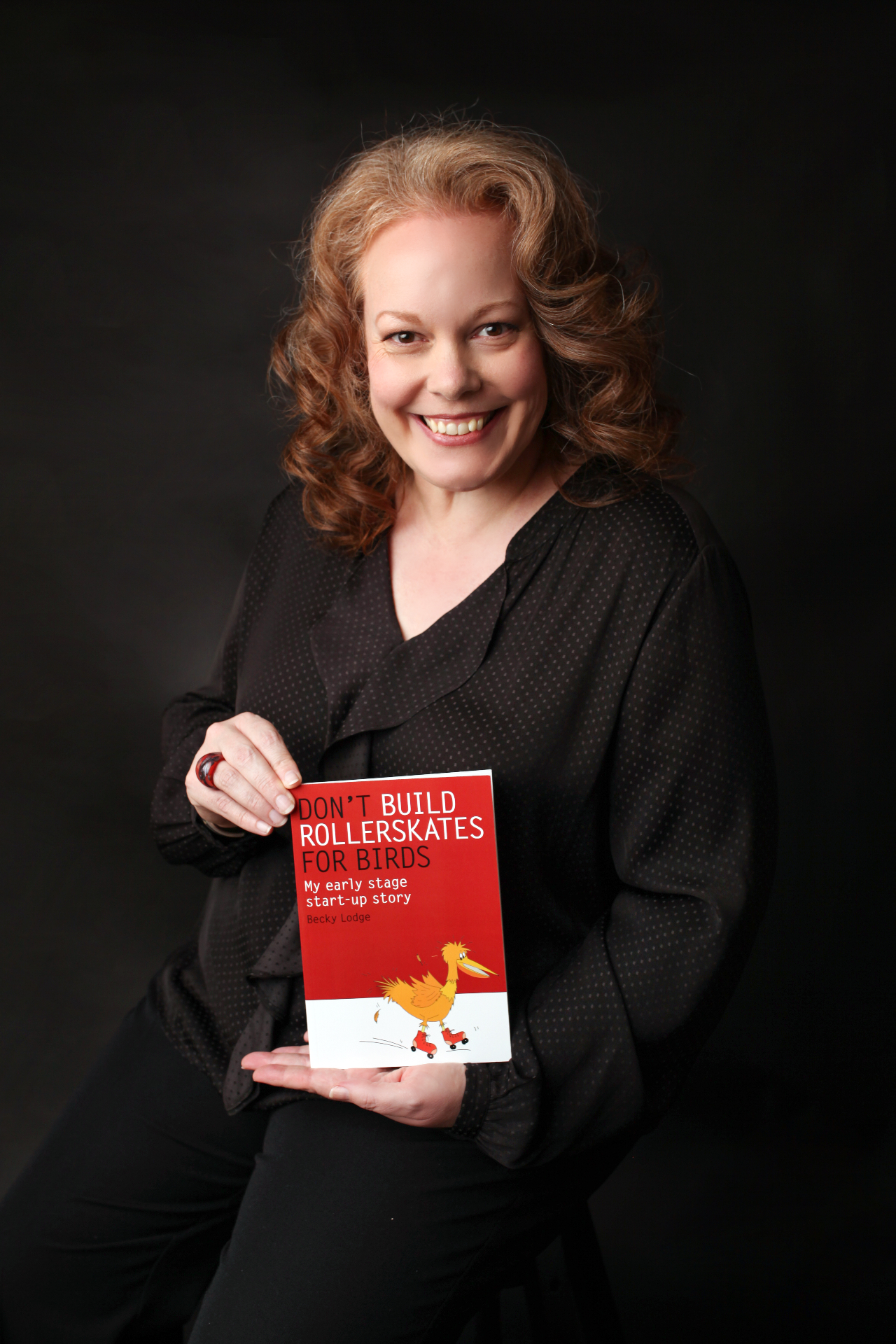 Becky Lodge holding her book 'Don't Build Rollerskates for Birds'